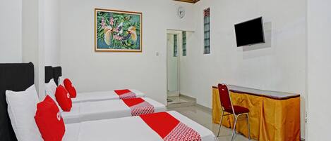 A hotel room with two beds, a desk, a chair, a TV, and a painting on the wall.