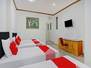 Une chambre d’hôtel avec deux lits, un bureau, une chaise, une télévision et un tableau au mur.