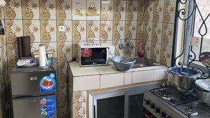 Eine Küche mit Mikrowelle, Spüle, Herd und dekorativen Fliesen.