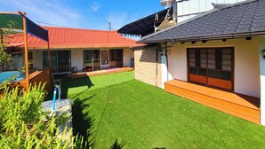 Una propiedad residencial con techo de tejas rojas, fachada de ladrillo y un césped bien cuidado.