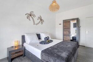 Een moderne slaapkamer met een bed, nachtkastje en een kunstwerk aan de muur.