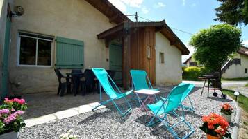 Un bâtiment doté d’un patio comprenant un espace extérieur aménagé avec des sièges et des plantes en pot.