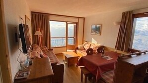 Una sala acogedora con un sofá, una mesa de comedor y un televisor.