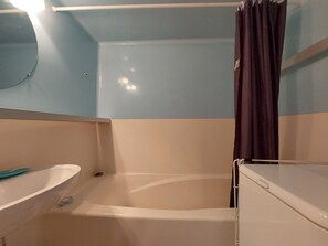A bathroom with a bathtub, a sink, and a mirror. - 2-room apartment, balcony, free Wifi (Les Arcs 1800)