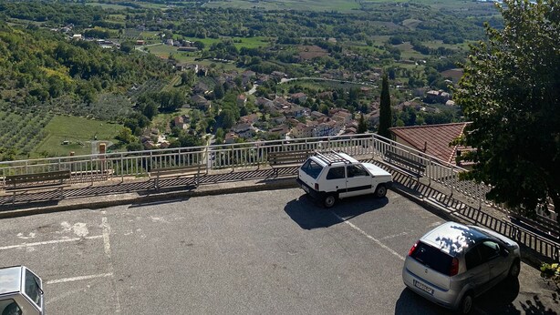 Un espace de stationnement offrant une vue sur une vallée et des montagnes.