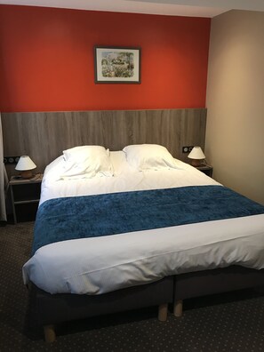 A hotel room with a large bed, two bedside lamps, a nightstand, and a framed picture on the wall. - HÔTEL LES FRANGINS (Saint-Omer)