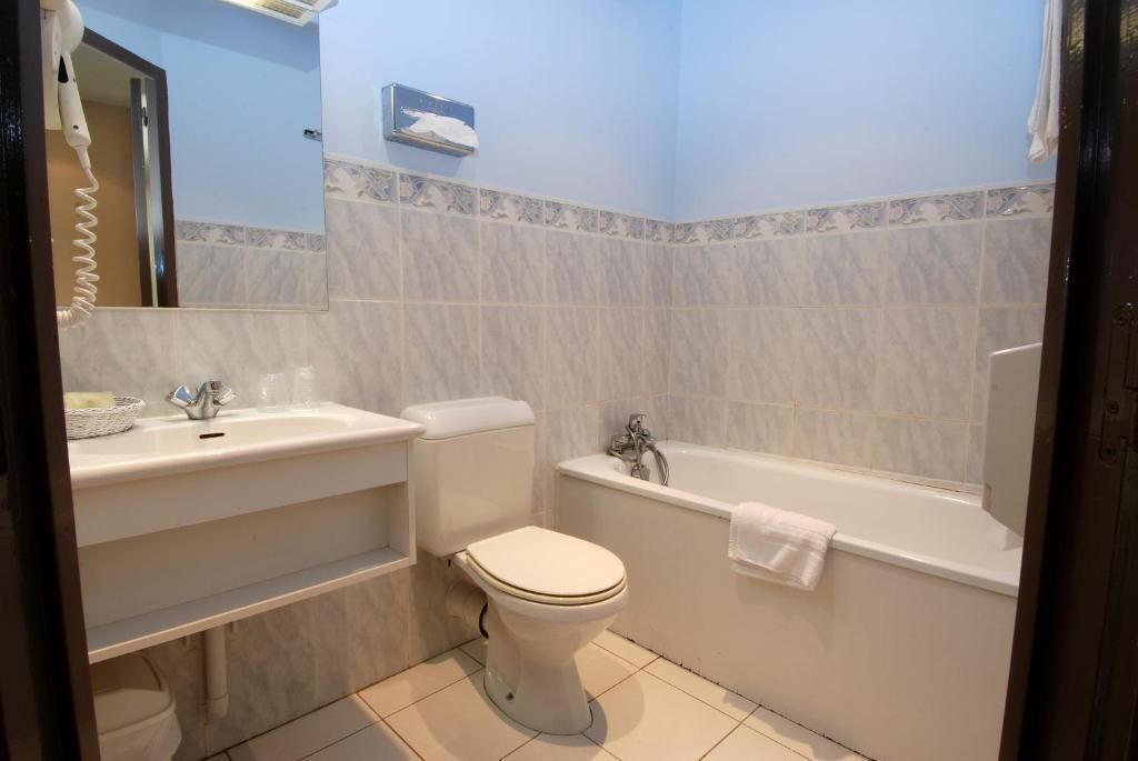 Une salle de bain avec des toilettes, un lavabo et une baignoire.