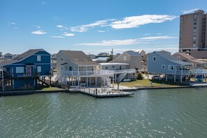 A waterfront property with a dock, multiple houses, and a large building in the background.