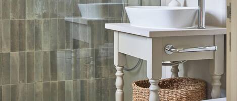Une salle de bain moderne avec une douche à parois de verre, un lavabo blanc et un grand miroir.