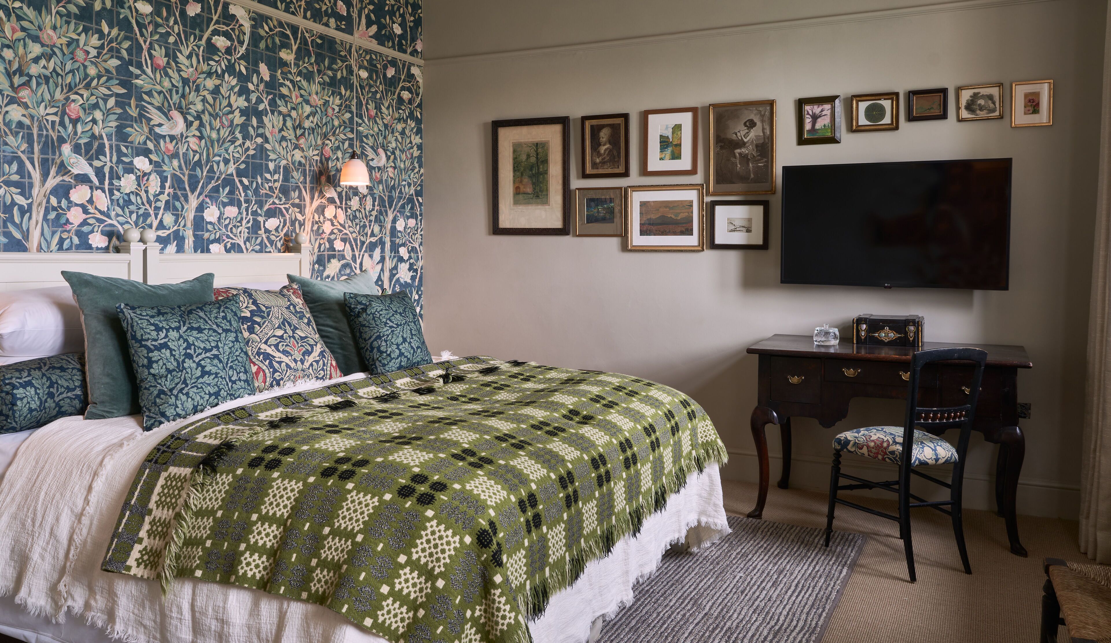 Un dormitorio con una cama grande, un escritorio y una televisión.