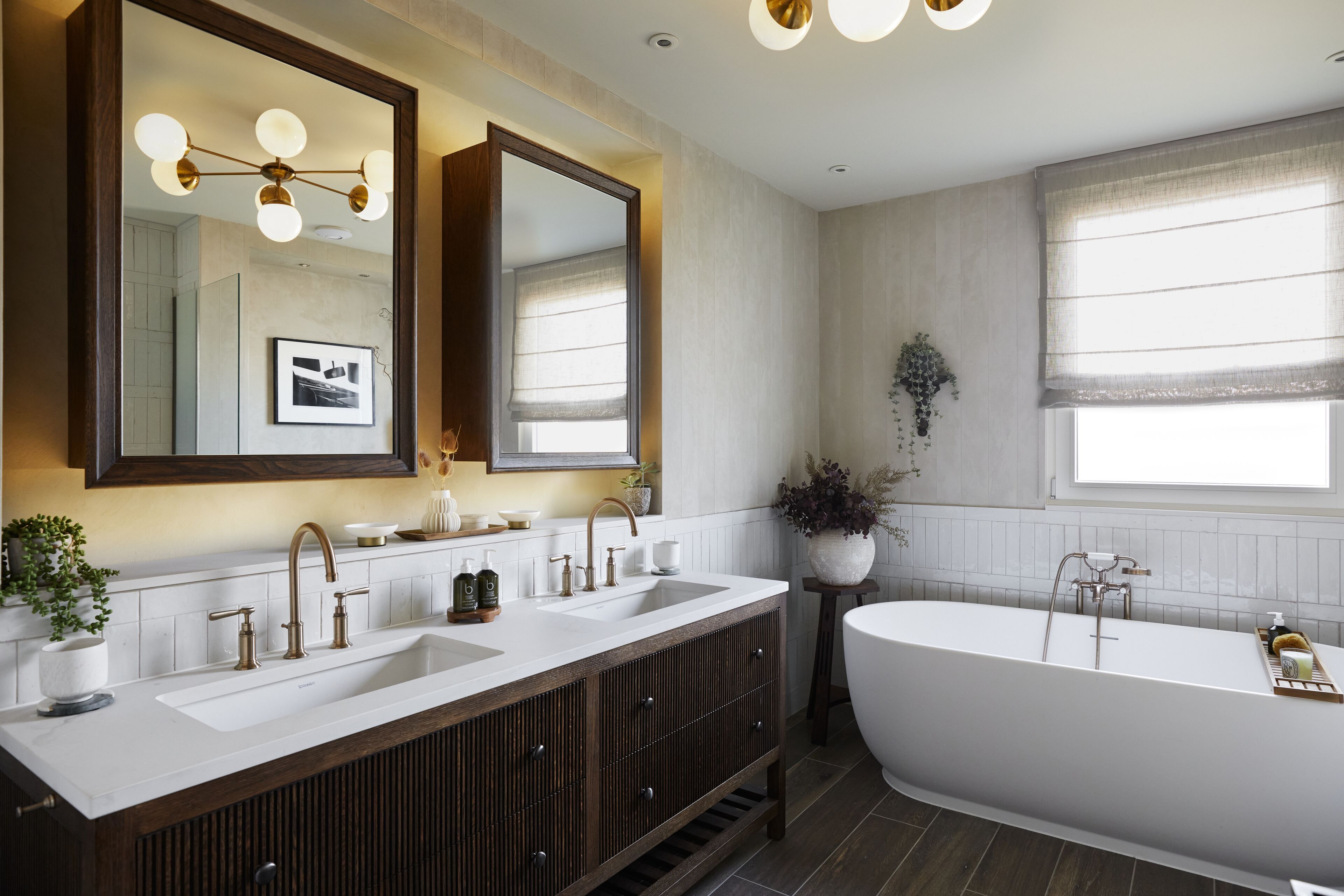 A modern bathroom with a freestanding bathtub, a double sink vanity, and a large mirror above the vanity.