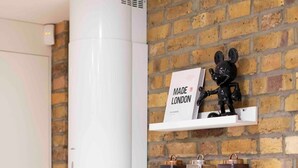 Eine Küche mit Ziegelwand, einer weißen Dunstabzugshaube, einer Mickey Mouse Figur und einem Toaster.