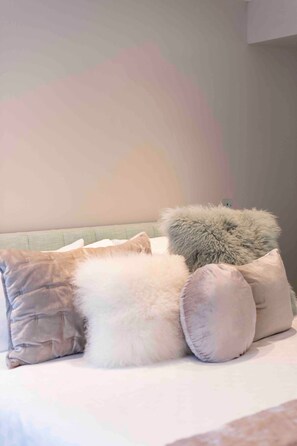 A bed with multiple pillows and a headboard against a plain wall. - Unbeatable location! Luxury 2Bed/2Bath Apartment! (London)