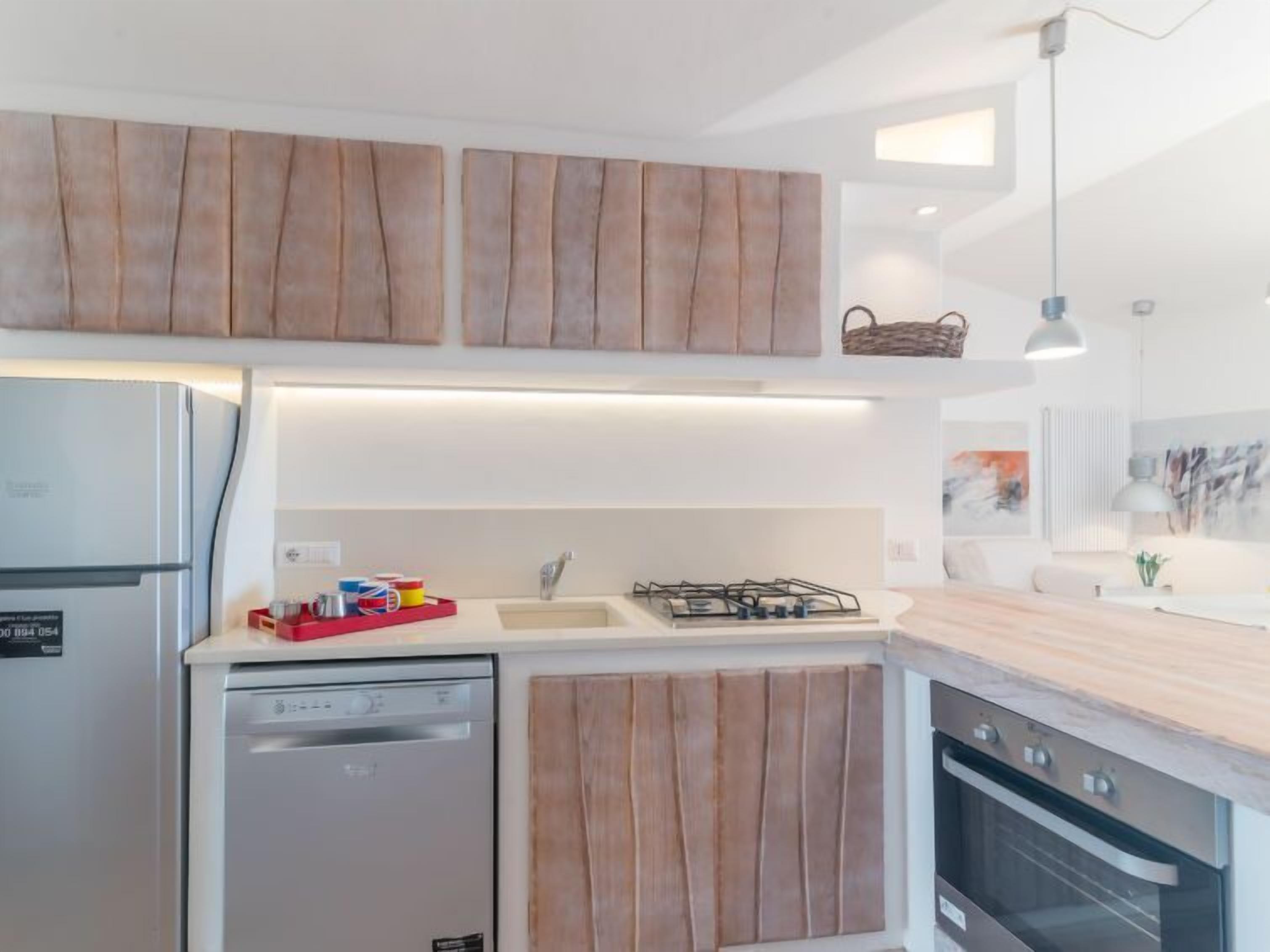 A modern kitchen with wooden cabinets, a dishwasher, a gas stove, and an oven.