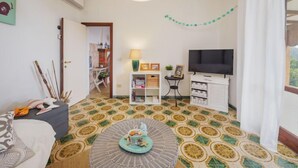A living room with a patterned floor, a television, a lamp, and a bookshelf. - Casa Giulia by Interhome (Seravezza)