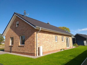 Situated on a well-manicured lawn, this single-story home features a gabled roof and a satellite dish.