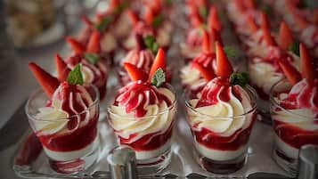 Eine Auswahl an Dessertgläsern mit Schlagsahne und Erdbeeren.