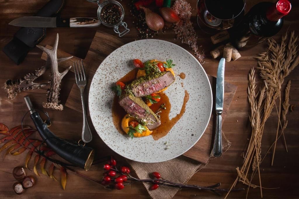 Ein Teller Essen mit Messer und Gabel auf einem Holztisch.