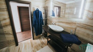 A modern bathroom with a marble floor, a dark wooden vanity, a white sink, and a large mirror. - Enjoy panoramic view of The Little Carpathian (Pezinok)