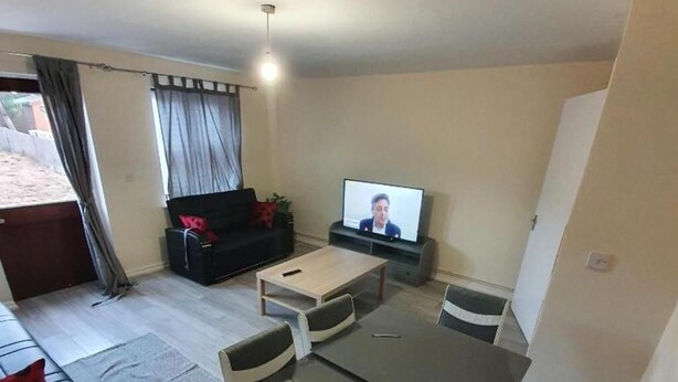 A living room with a sofa, a coffee table, and a TV. - 4 Bed House Sleeps 12 - Private Garden - Parking (London)