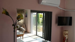 A room with a bed, a TV, and an air conditioning unit. - Lovely Modern Studio in Romanos Patras, Greece (Patras)