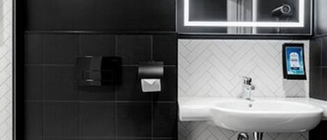 A modern bathroom with a toilet, sink, and mirror.