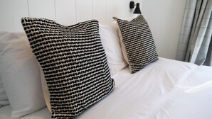 A bed with white bedding and two large, black and white patterned pillows. - Sea Glass -  a lodge that sleeps 4 guests  in 2 bedrooms (Gatehouse of Fleet)