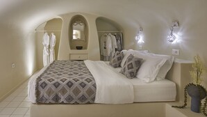 Une chambre à coucher avec un lit, un miroir et un porte-vêtements suspendu.
