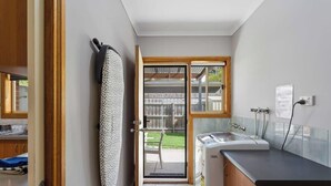 Una cocina compacta con lavavajillas integrado, una ventana con vista a un patio trasero y una puerta que da a un área de patio.