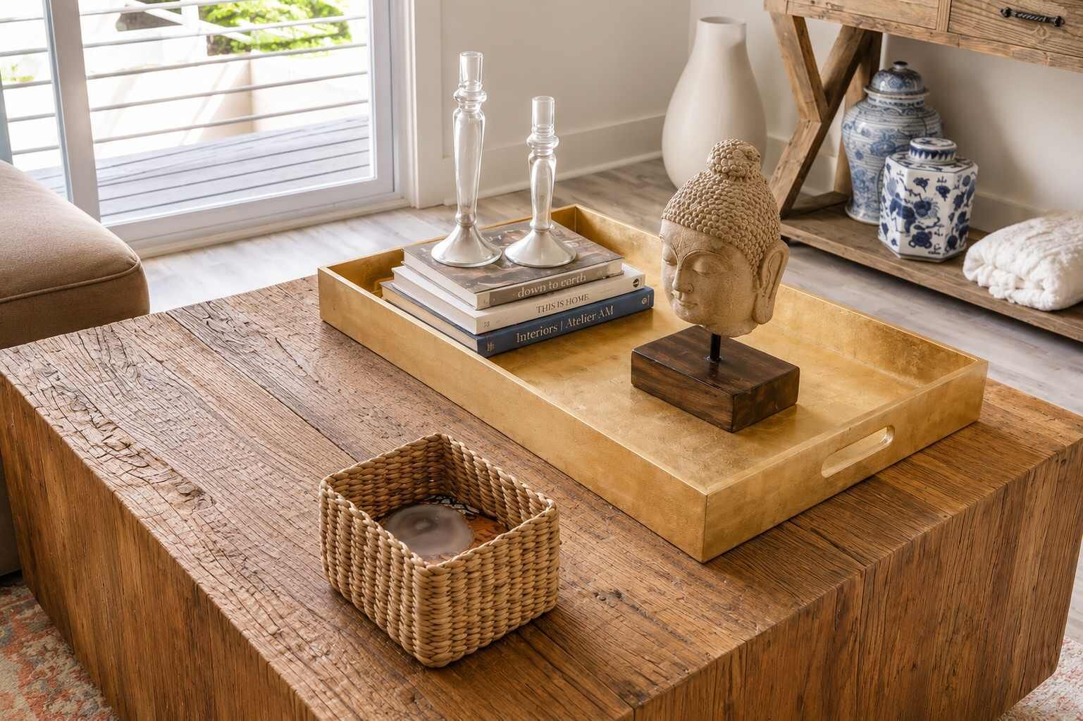 Ein Holztisch mit einem gewebten Korb, einer Buddha-Statue und dekorativen Vasen.