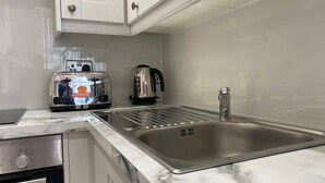A kitchen with a stainless steel sink, a built-in oven, and a toaster.