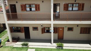 A two-story building with a balcony on each floor, solar panels on the roof, and a sign indicating 'AVISO'. - Pousada das Bandeiras (Olímpia)