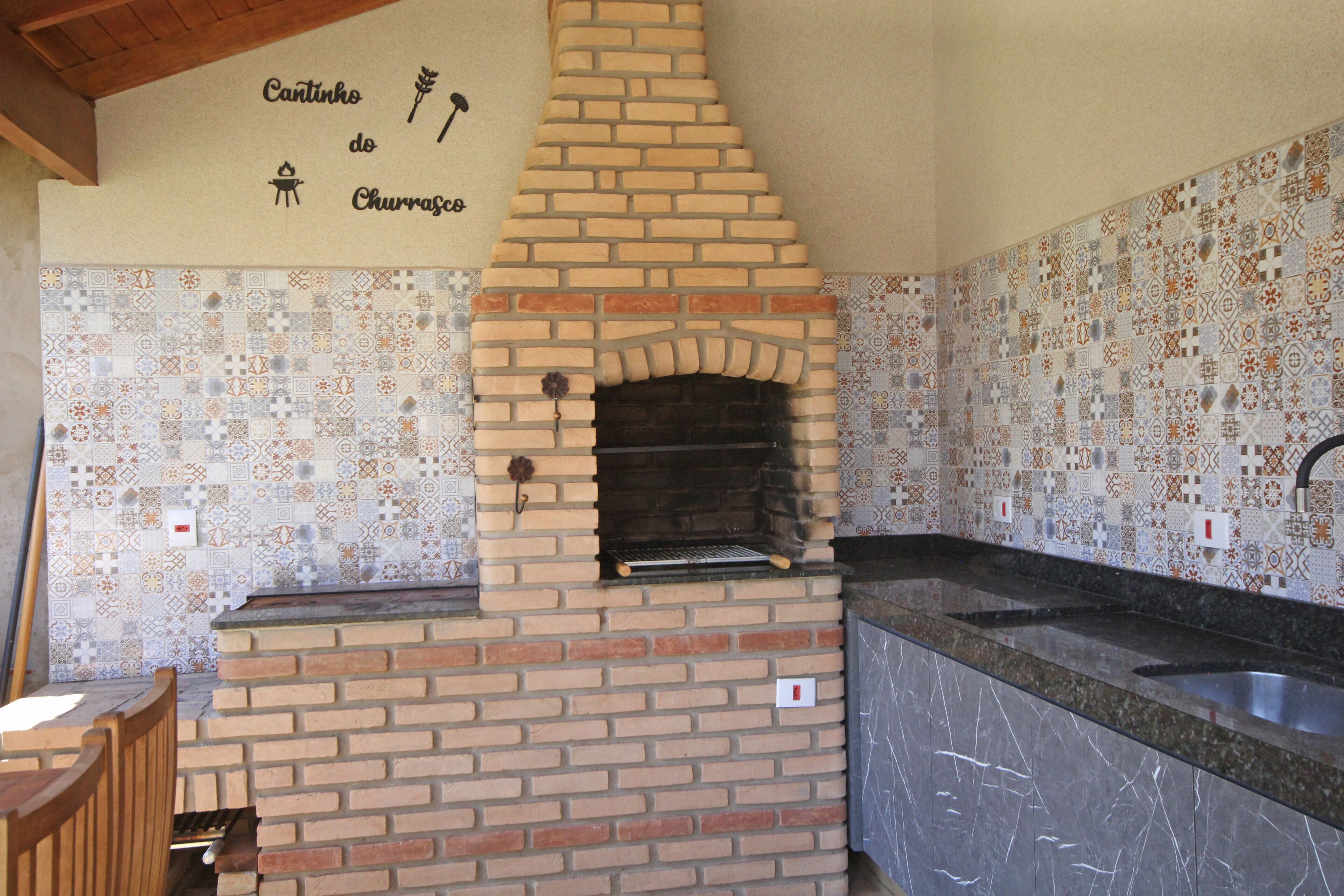 Een keuken met een bakoven, decoratieve tegels en een houten stoel.