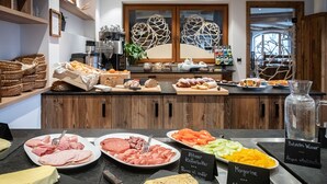 A buffet with various food items and a coffee machine. - Naturhotel Waldheim (Anterivo)