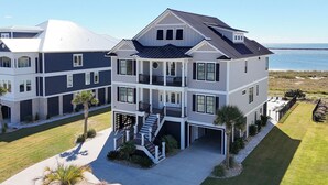 Un edificio residenziale a più piani con un balcone, un portico coperto e vista sull'oceano.