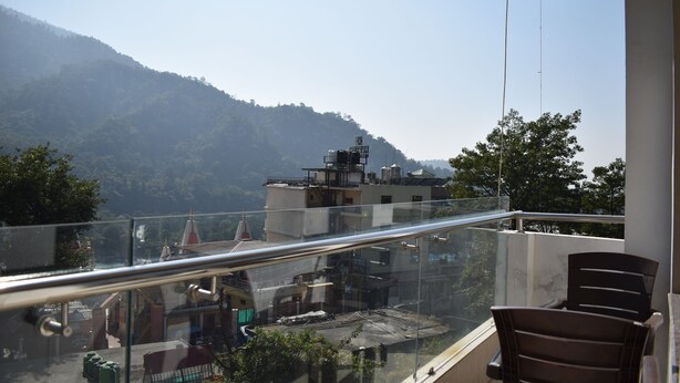 A balcony with a glass railing overlooking a mountainous landscape. - Tapasthali By Meera Hotels (Narendranagar)