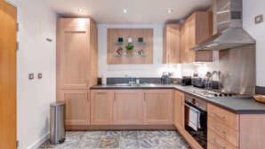 Una cocina moderna con armarios de madera, extractor de acero inoxidable y salpicadero de azulejos.