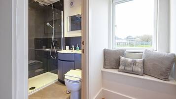 Une salle de bain moderne avec une douche à parois de verre, des toilettes blanches et un lavabo.