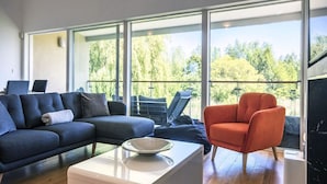 Ein modernes Wohnzimmer mit einer Couch, einem Sessel und einem Couchtisch.