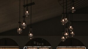 A bar area with a counter, stools, and shelves of bottles and glasses. - Wander the Resort (Prince Edward)