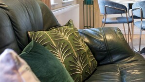 A leather sofa with green cushions in a room with a dining area and a potted plant. - Stunning 2BR Apt with Balcony Next to Queens Uni - Pass the Keys (Belfast)