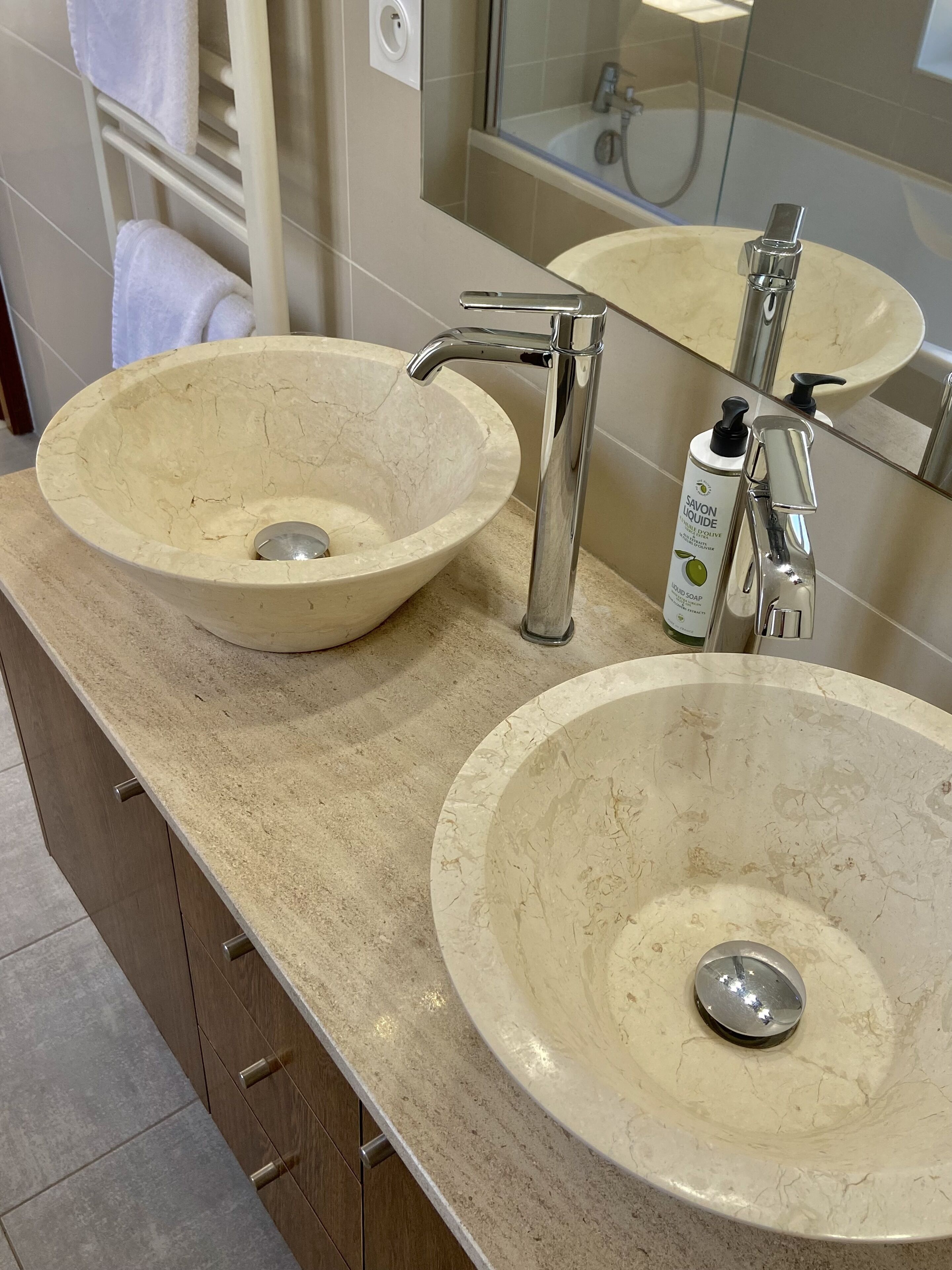 Un baño con dos lavamanos, un espejo y un perchero para toallas.