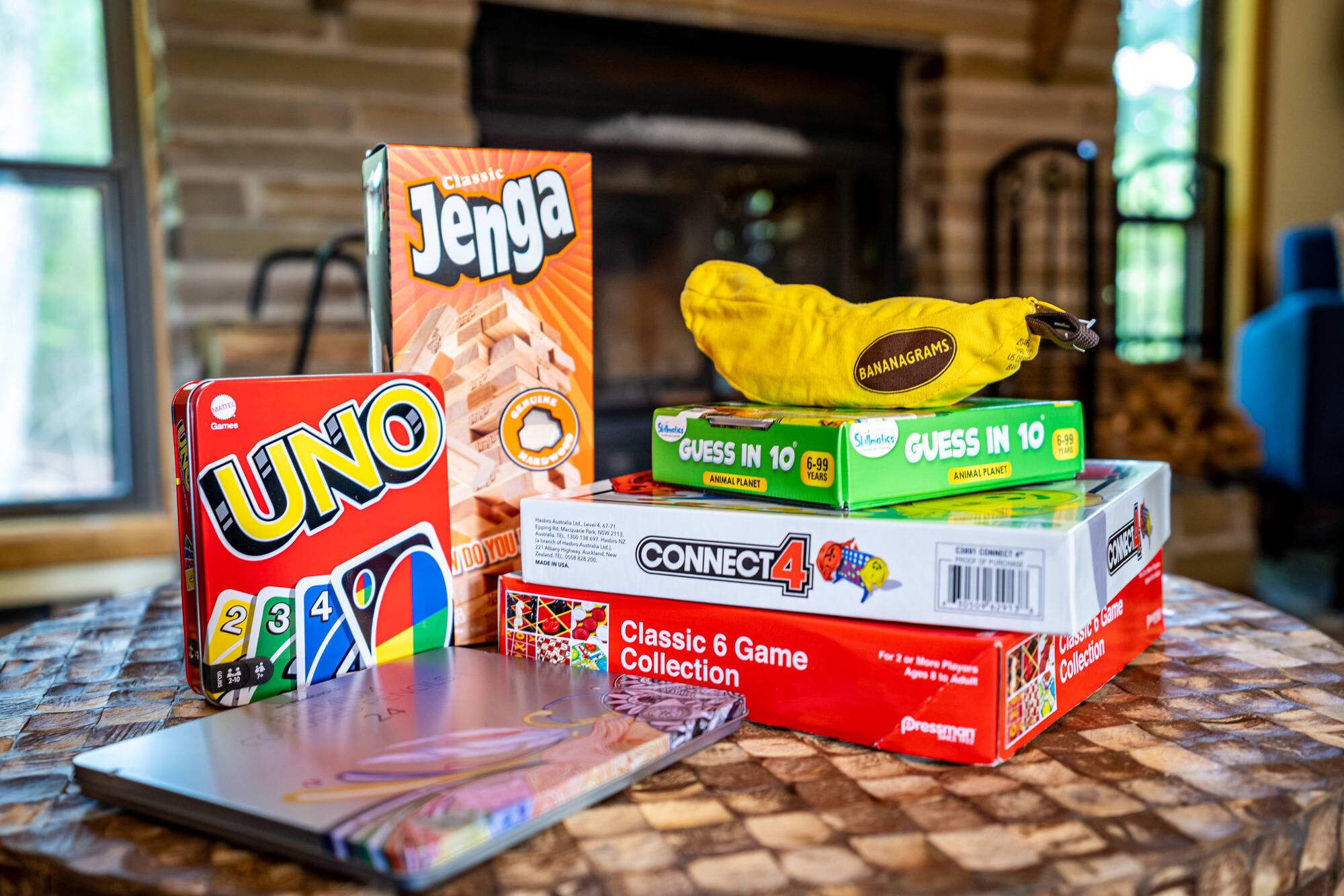 Un tavolo con diversi giochi da tavolo, tra cui UNO, Jenga e Connect 4.