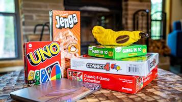 Un tavolo con diversi giochi da tavolo, tra cui UNO, Jenga e Connect 4.