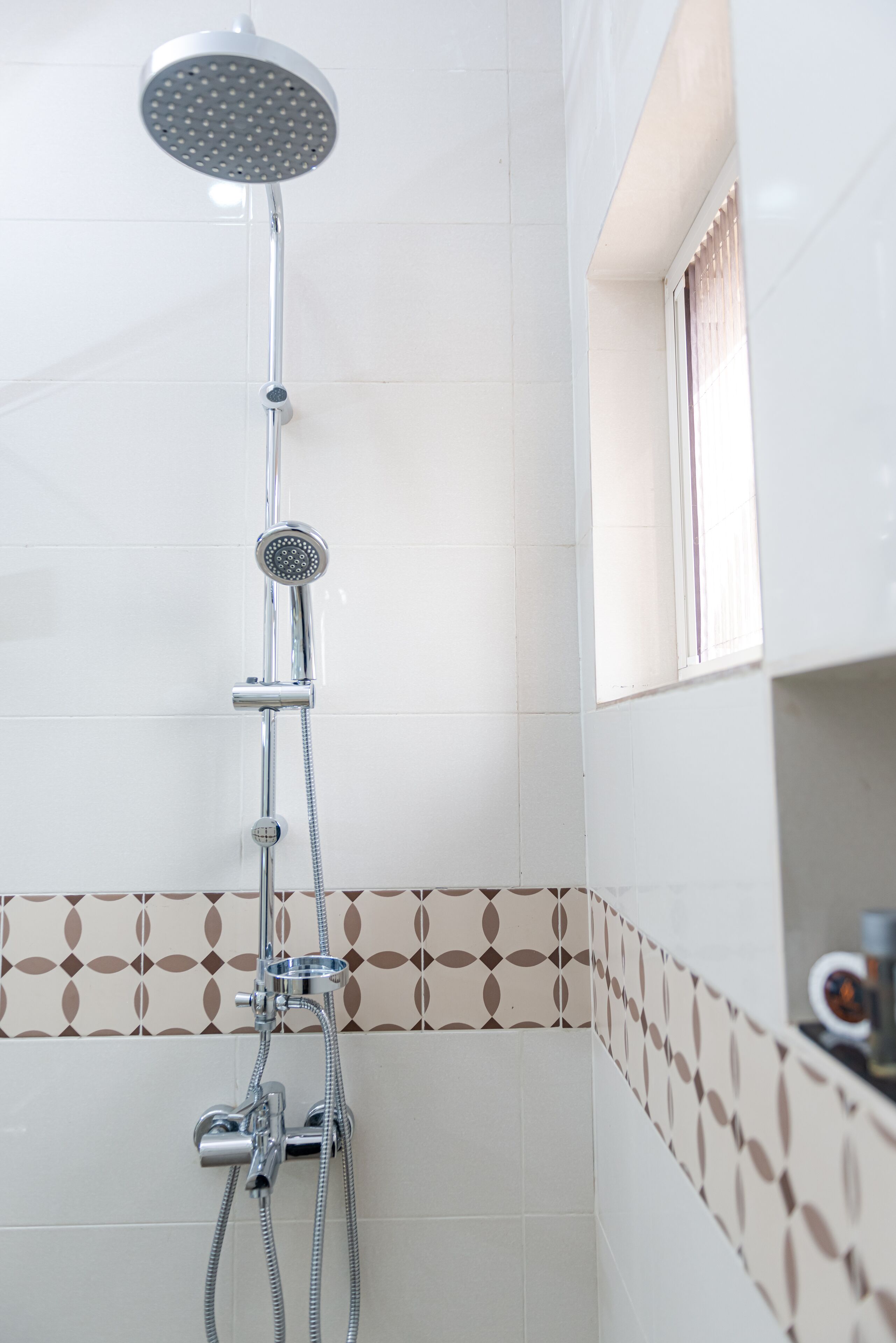 A shower with a handheld showerhead and a handheld faucet.