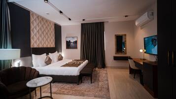 Una habitación de hotel moderna con una cama grande, un escritorio, una silla y un televisor.