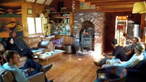 Ein gemütliches Wohnzimmer mit Kamin, Holzdielen und einer Bücherwand.