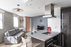 Enjoy a comfortable stay in this stylish apartment with a sleek living area, dining table, and kitchen.