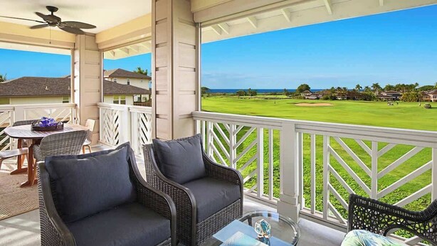 A covered outdoor area with wicker furniture, a glass table, and a view of a golf course. - Pili Mai 7E - Top Floor 3 - Bed Suite On Golf Course - AC, Pool & Fitness Center (Koloa)