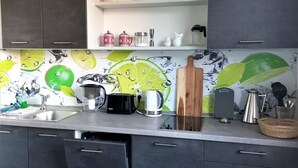 Una cocina moderna con armarios oscuros, encimera blanca y salpicadero con diseño de rodaja de lima.